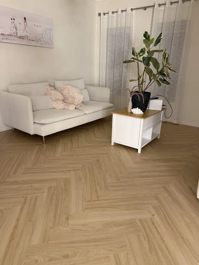 Herringbone flooring in a living room with white sofa