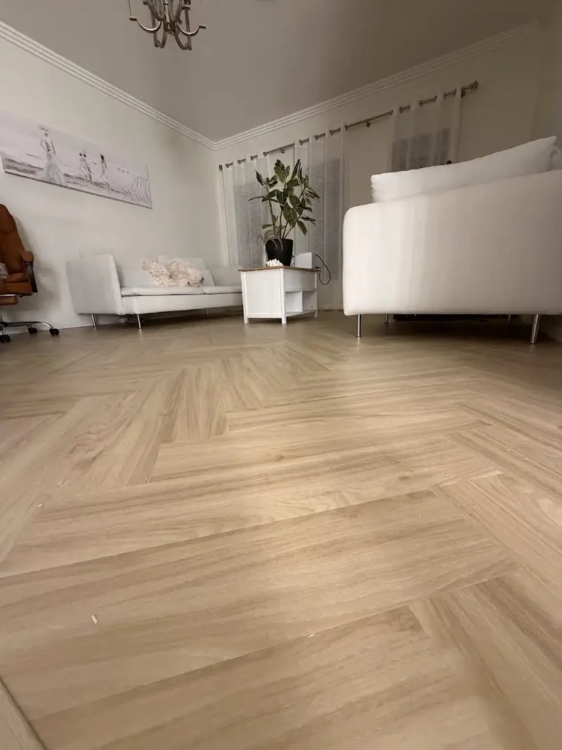Herringbone flooring in a bright living room with white sofa