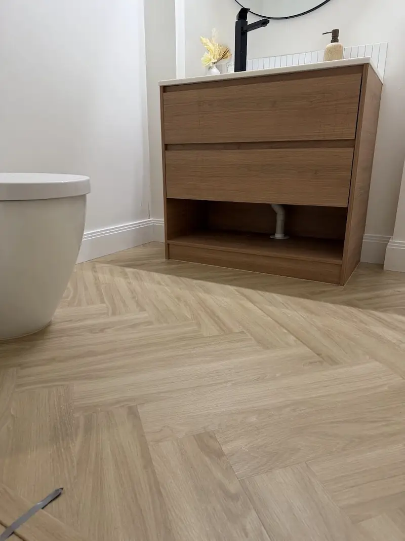 Herringbone flooring in a bathroom beside a timber vanity