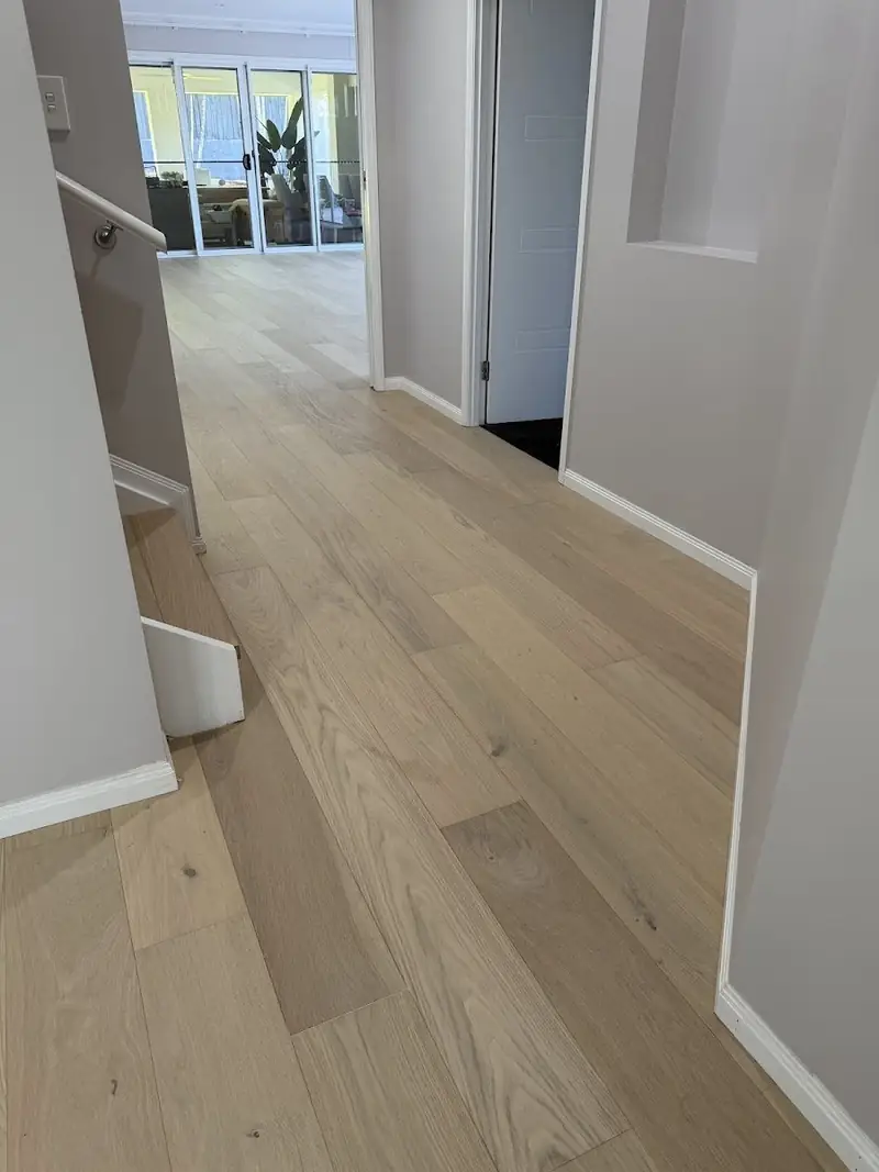 Pale engineered oak hallway opening to a living area