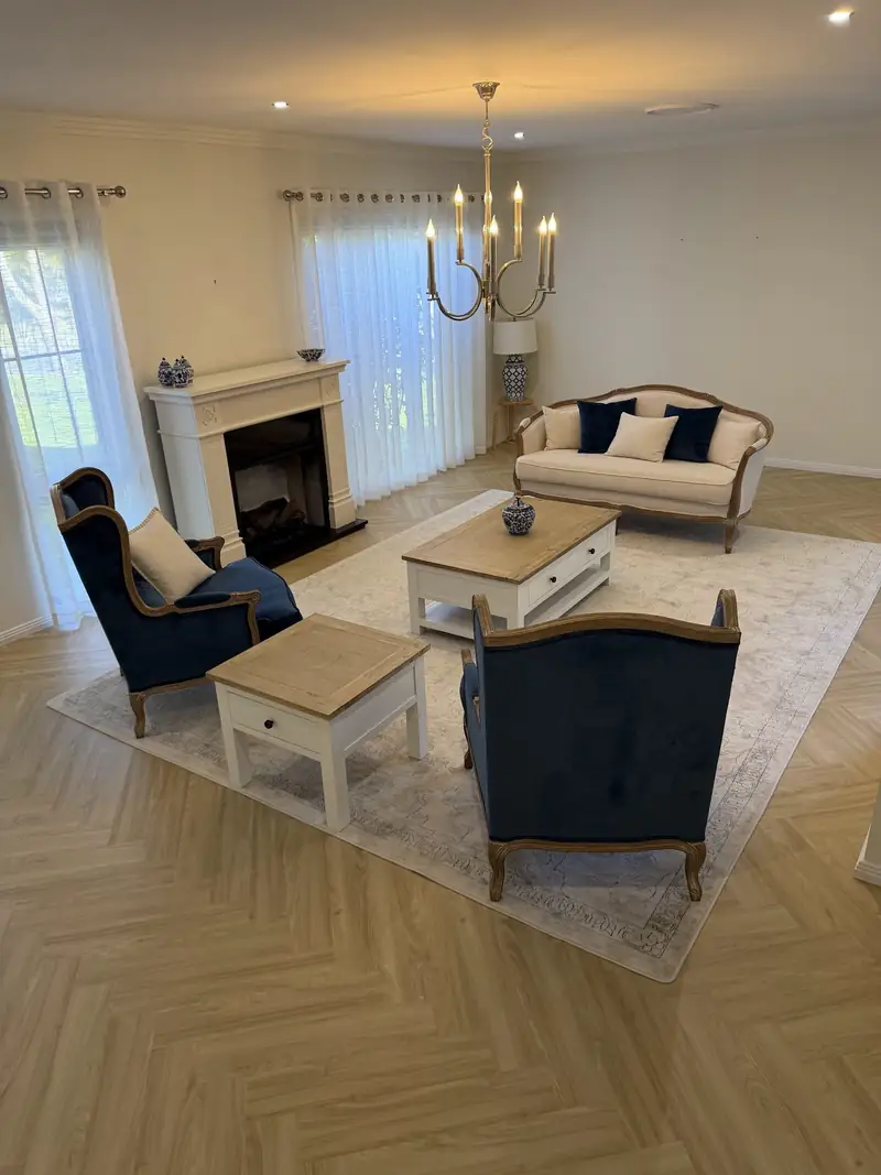 Herringbone flooring in a furnished living room with fireplace and chandelier