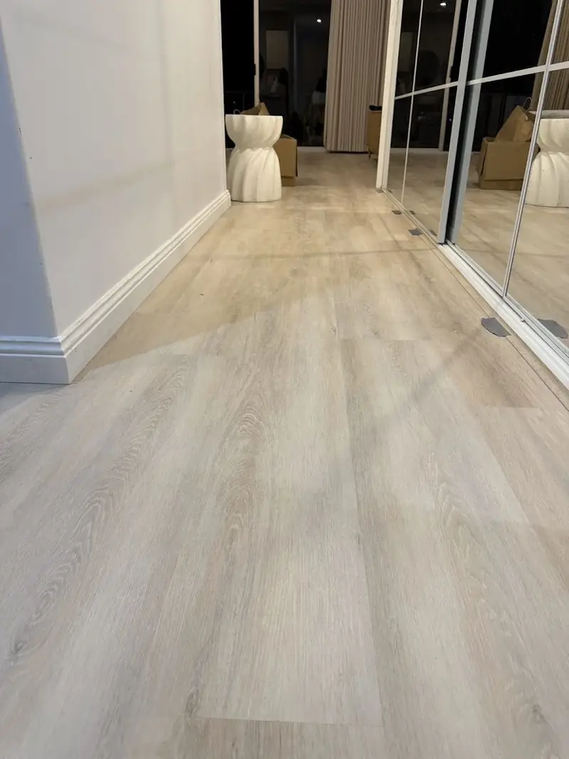 SPC hybrid flooring in a hallway leading to glass doors