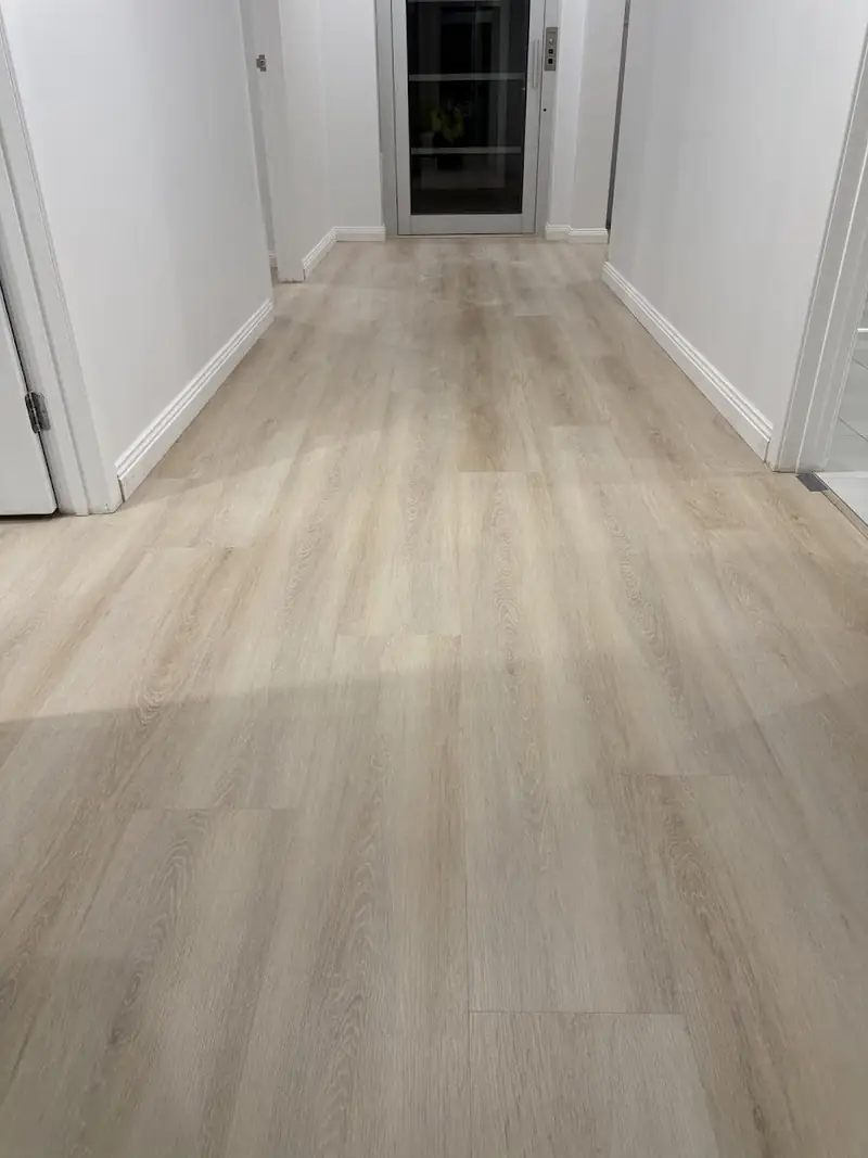 SPC hybrid flooring in a hallway with a door at the end