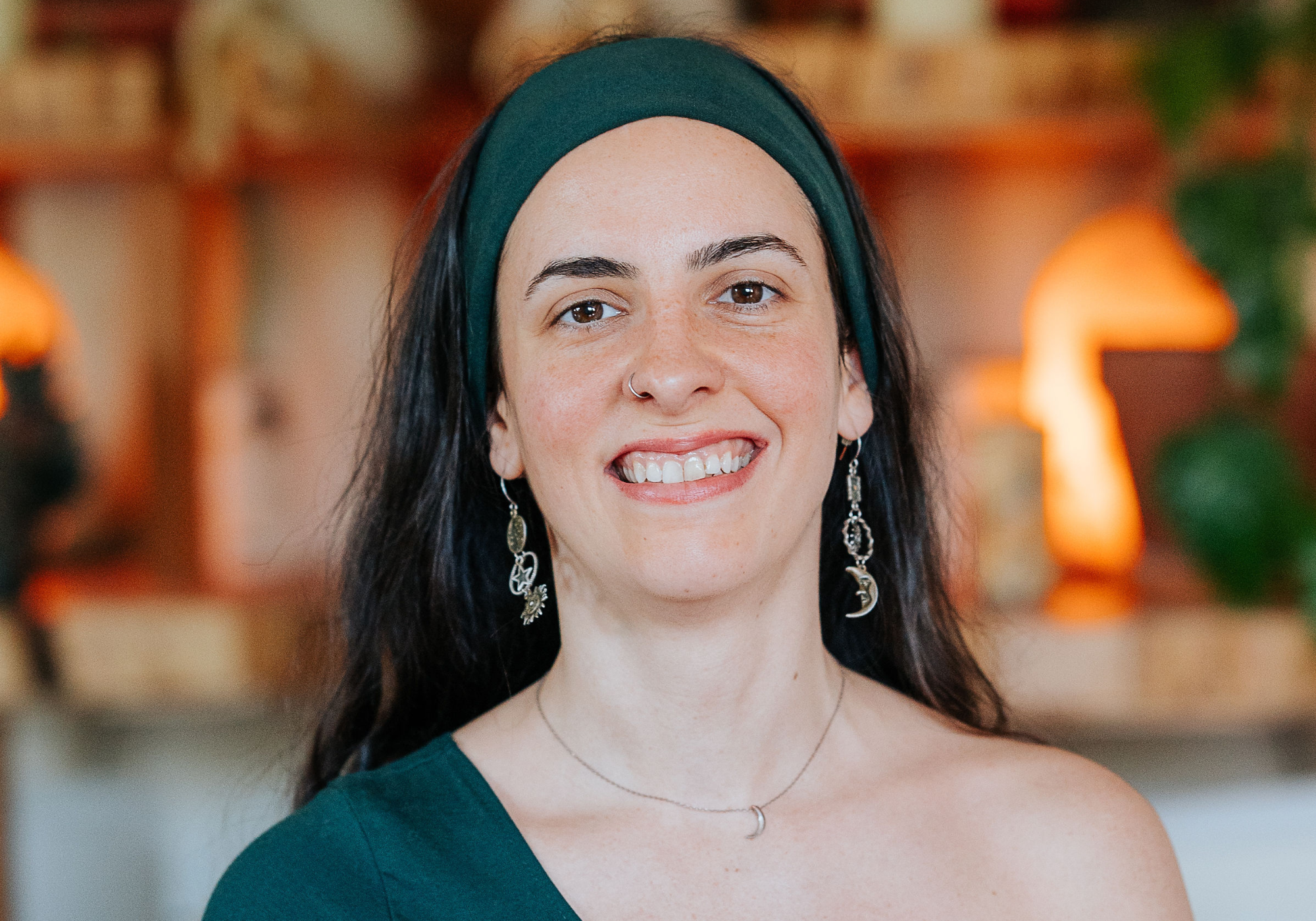 Radiant smile of a yoga instructor in a navy blue top, her joyful expression reflecting the positive and uplifting environment of Shala Yoga studio in Squamish, inviting a sense of community and wellbeing.