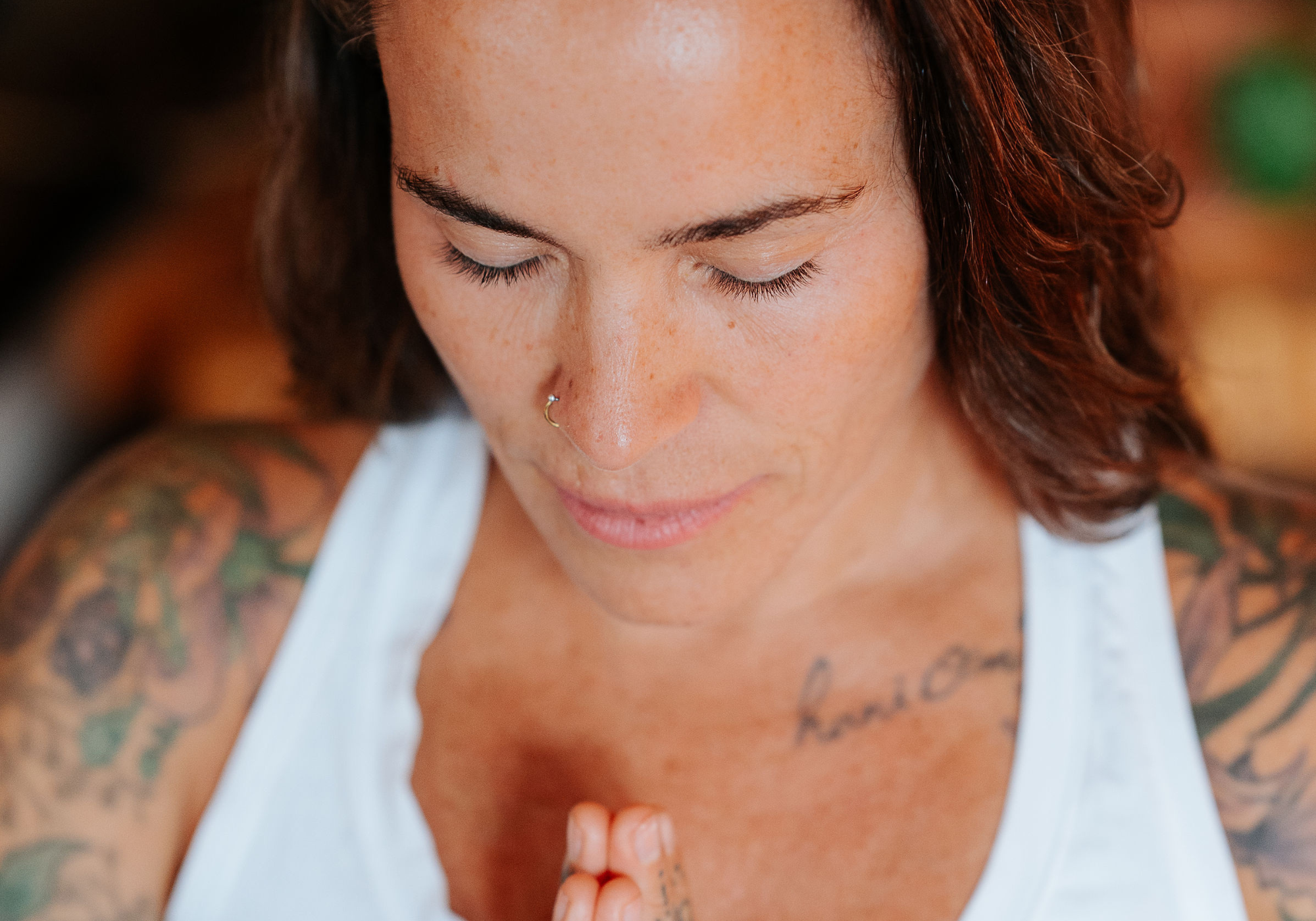 Monochrome image of a dedicated yoga instructor demonstrating an advanced split pose at Shala Yoga studio in Squamish, her tattoos adding to the artistic expression of strength and flexibility