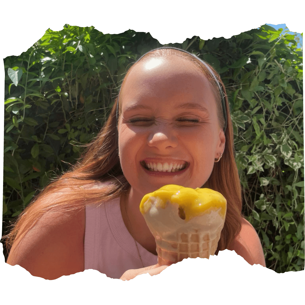 A woman joyfully eating an ice cream cone in the sunshine