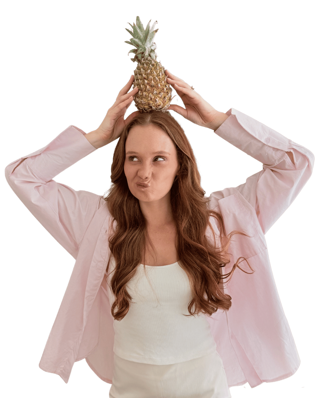 Mikaela playfully balancing a pineapple on her head