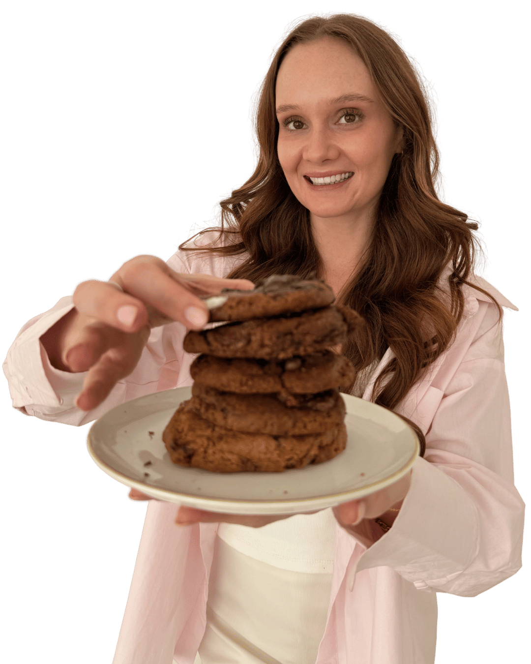 Mikaela smiling and holding a plate of stacked chocolate cookies