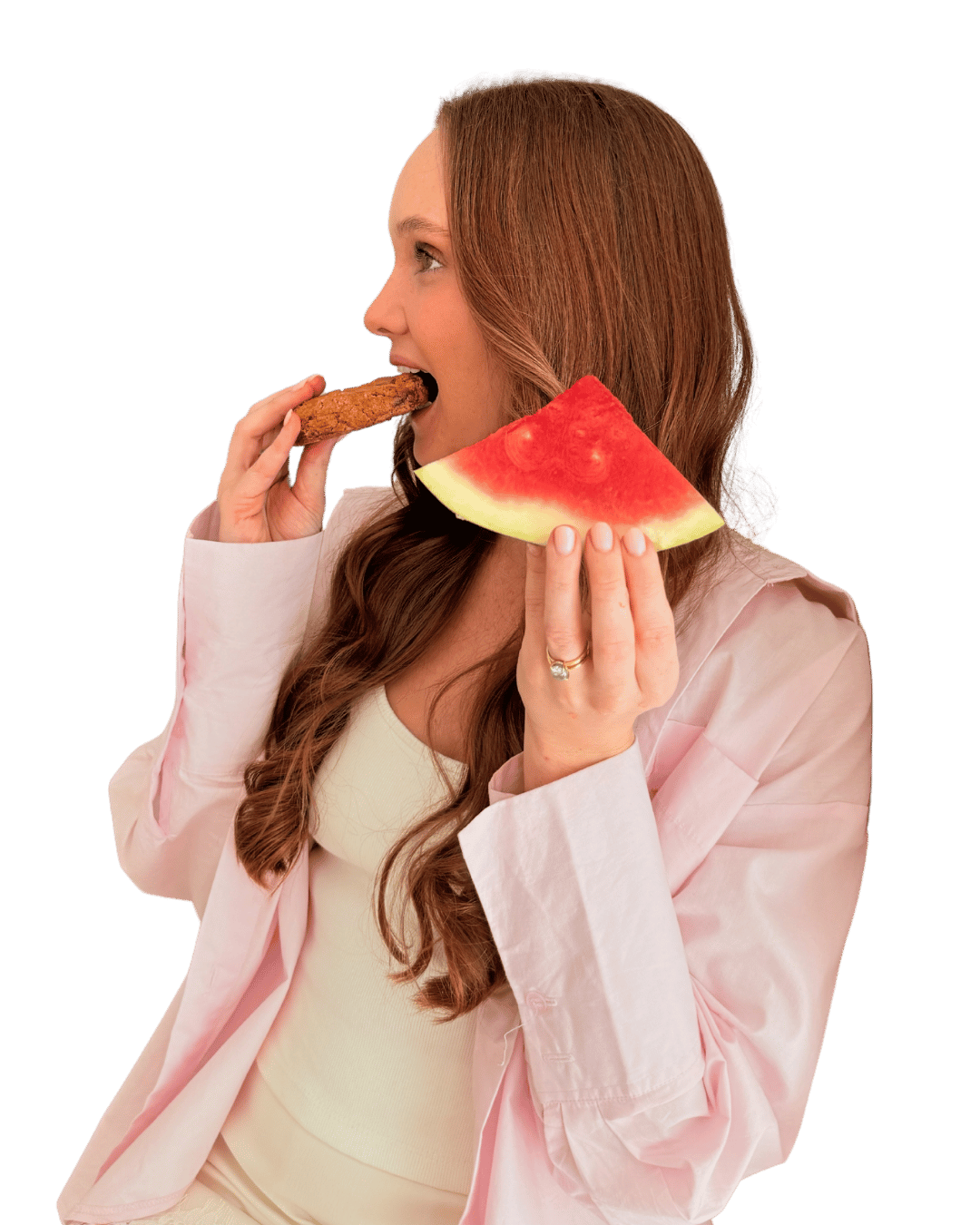 Mikaela enjoying a cookie in one hand and watermelon in the other