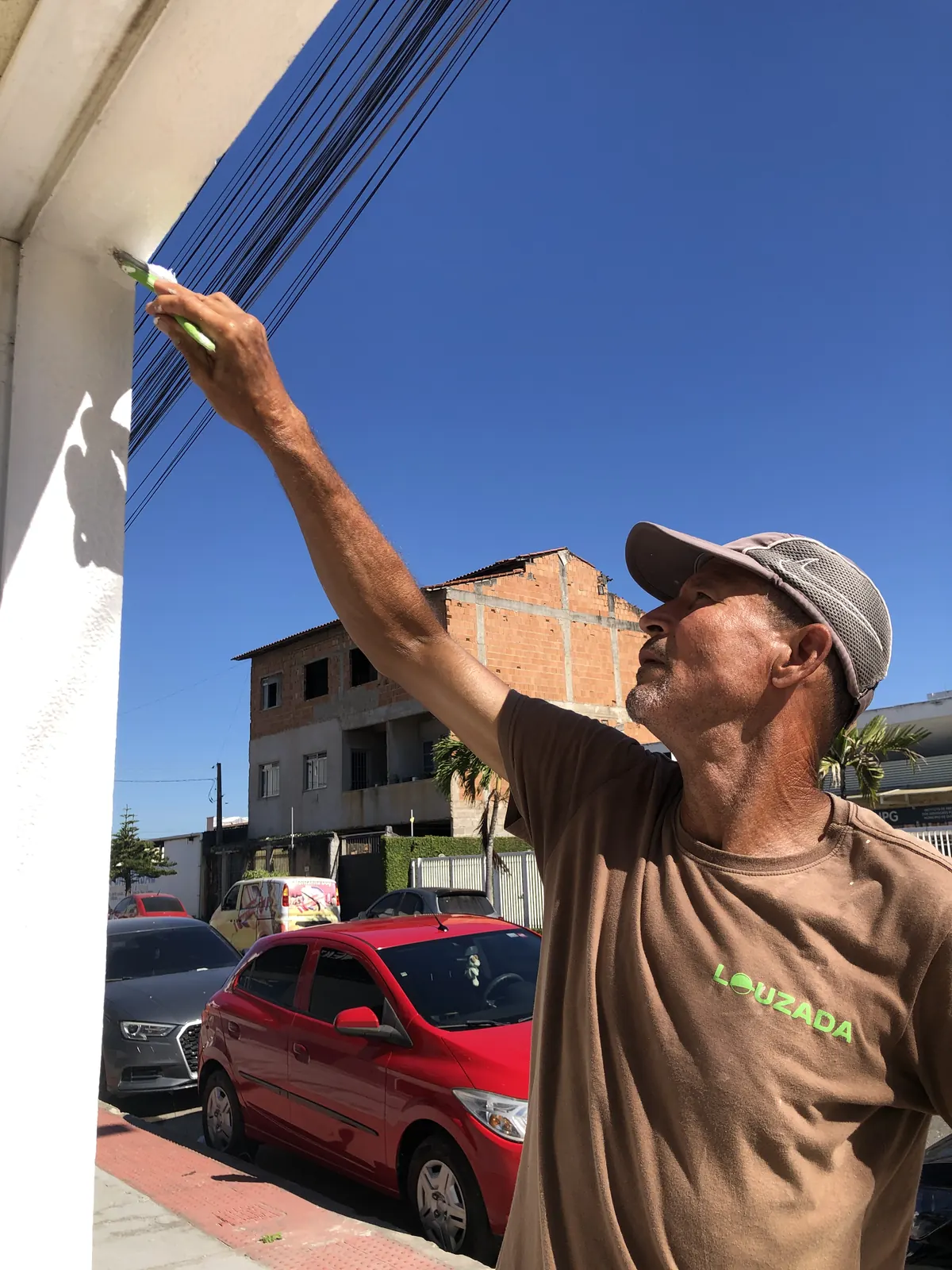 Profissional Louzada executando acabamento de pintura em fachada
