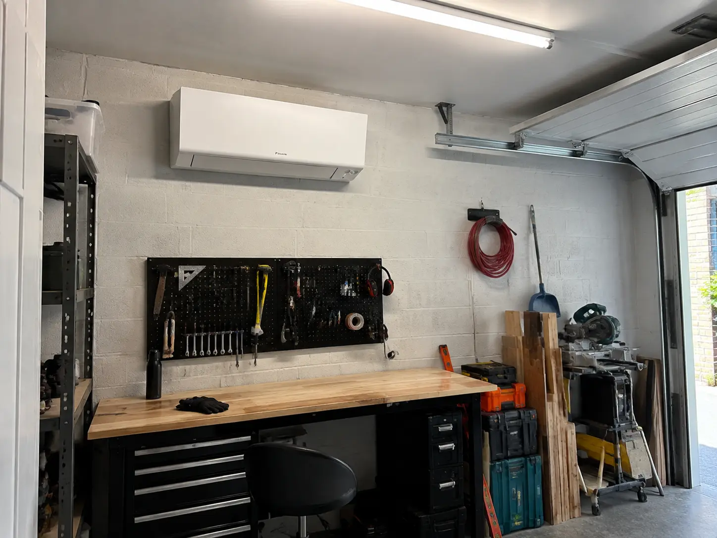 A Daikin wall unit above the workbench in a garage workshop