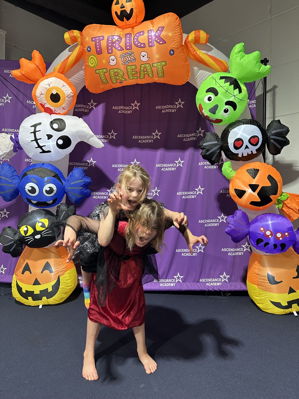 Two kids pulling playful monster faces in costume at the studio