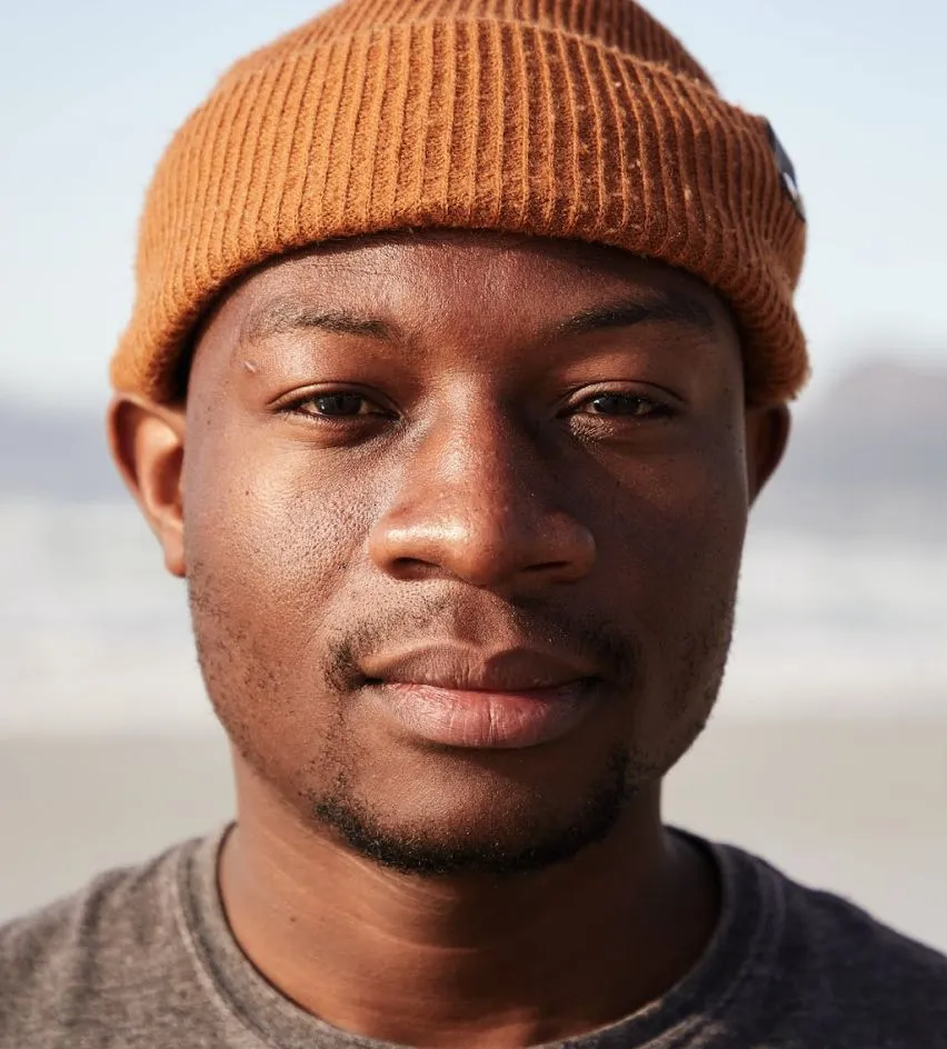 	Young man smiling calmly outdoors, symbolizing strength and recovery. 