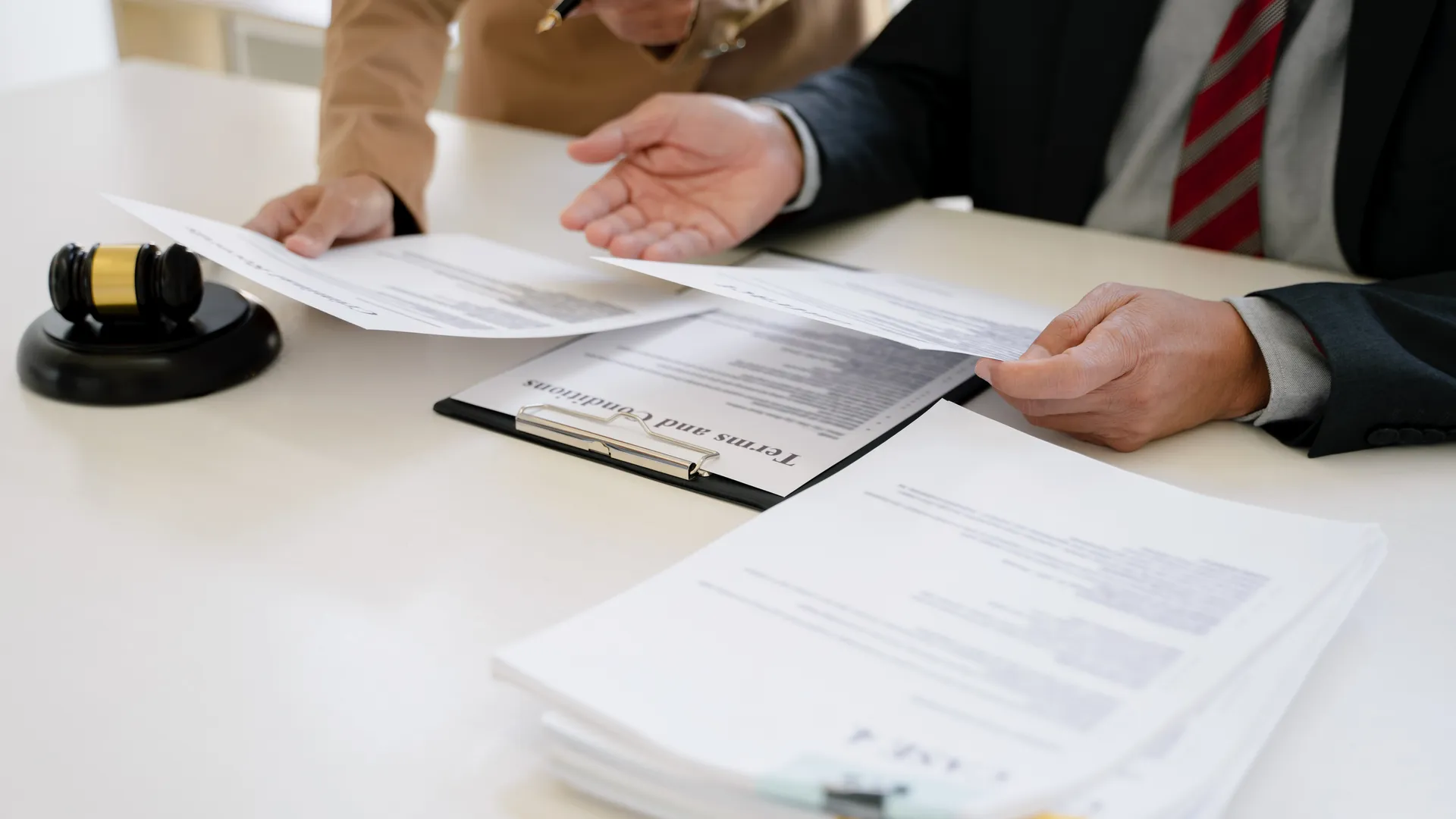 Two people signing legal paperwork, representing legal processes.