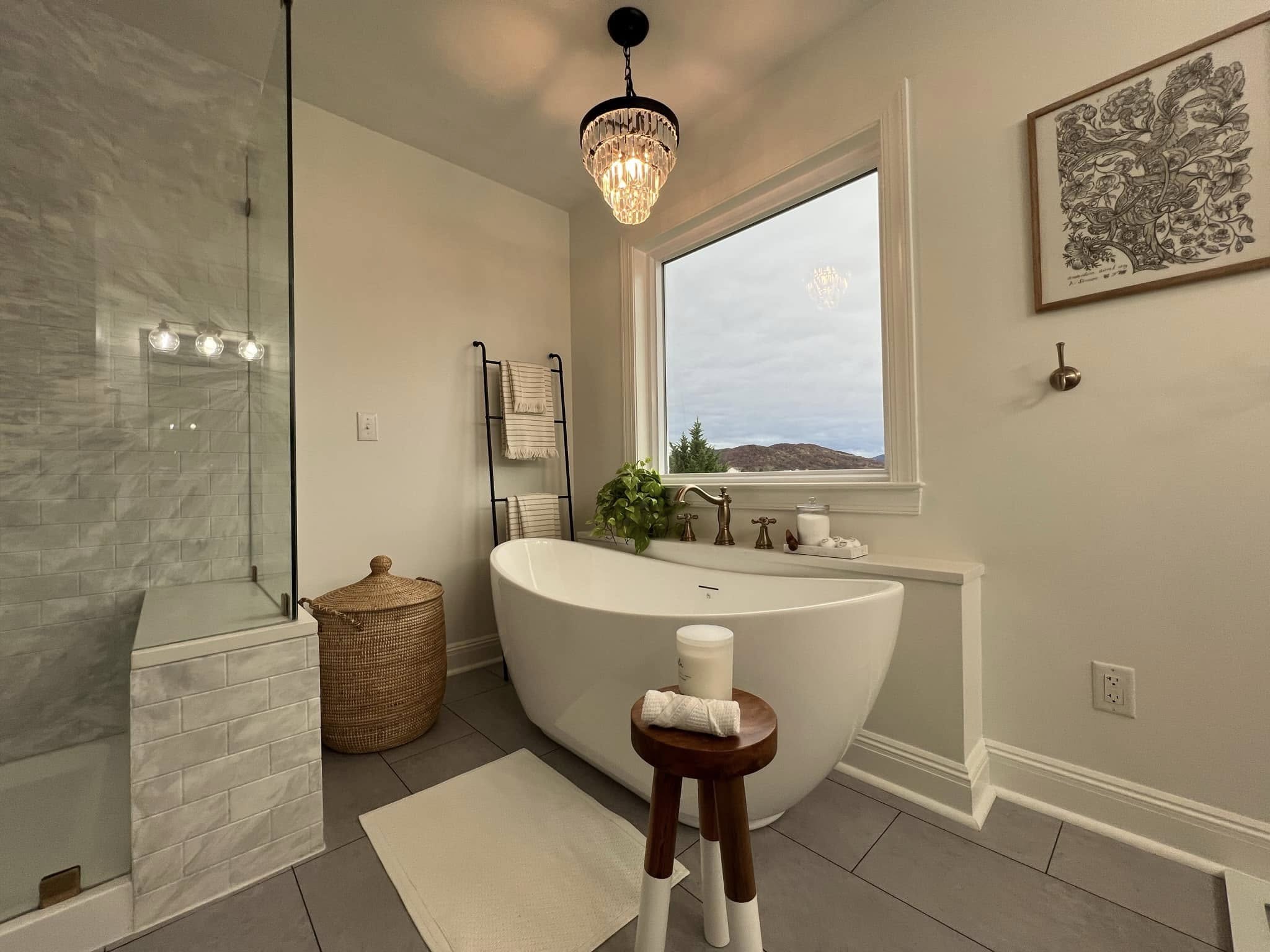 Completed primary bathroom
renovation with freestanding tub, glass shower, and mountain view