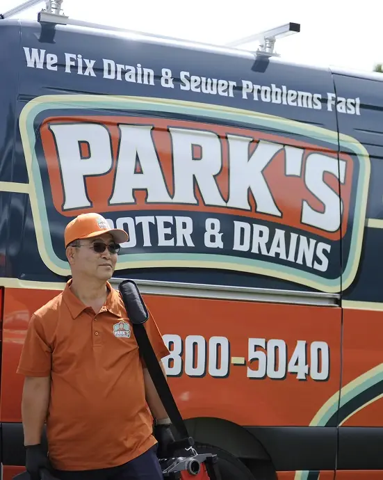Park's Rooter & Drains technician in front of the company van
