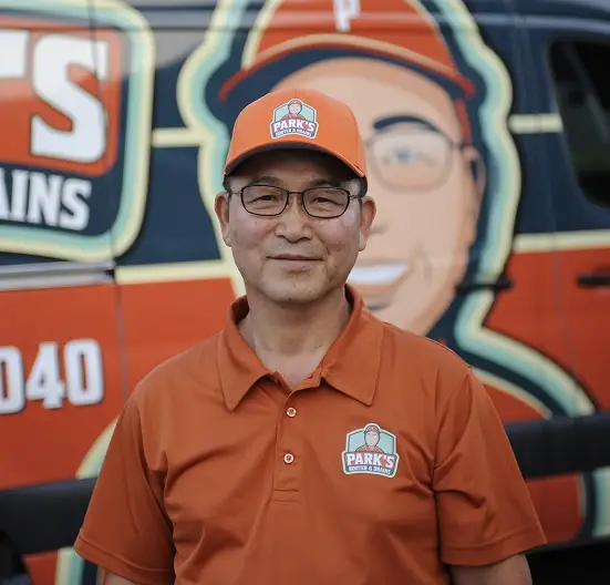 Park's Rooter & Drains plumber in front of the company van
