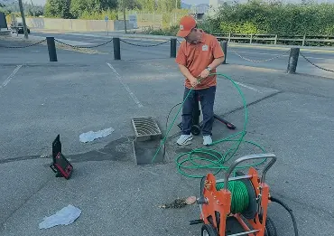 Technician cleaning a sewer line with a drain machine