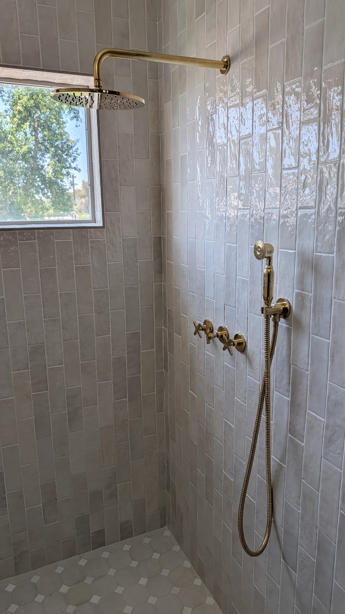 Finished shower and brass trim by Chokehold Plumbing