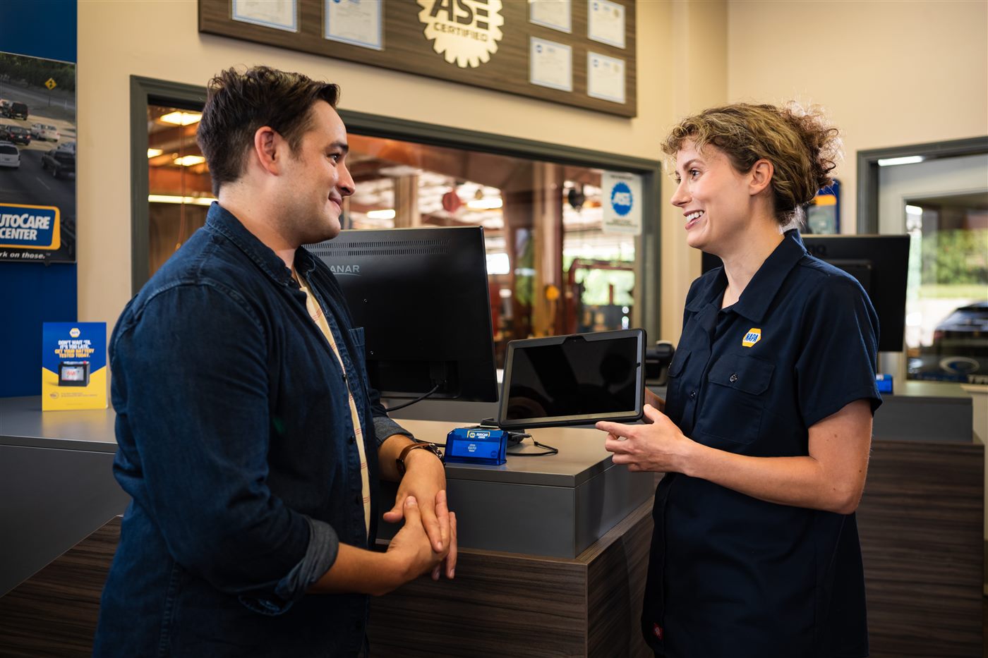 NAPA service advisor reviewing a vehicle report with a customer at the ChekoSZ AutoService front counter