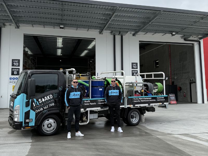 The SOAKD team standing beside their branded truck loaded with commercial-grade exterior cleaning equipment