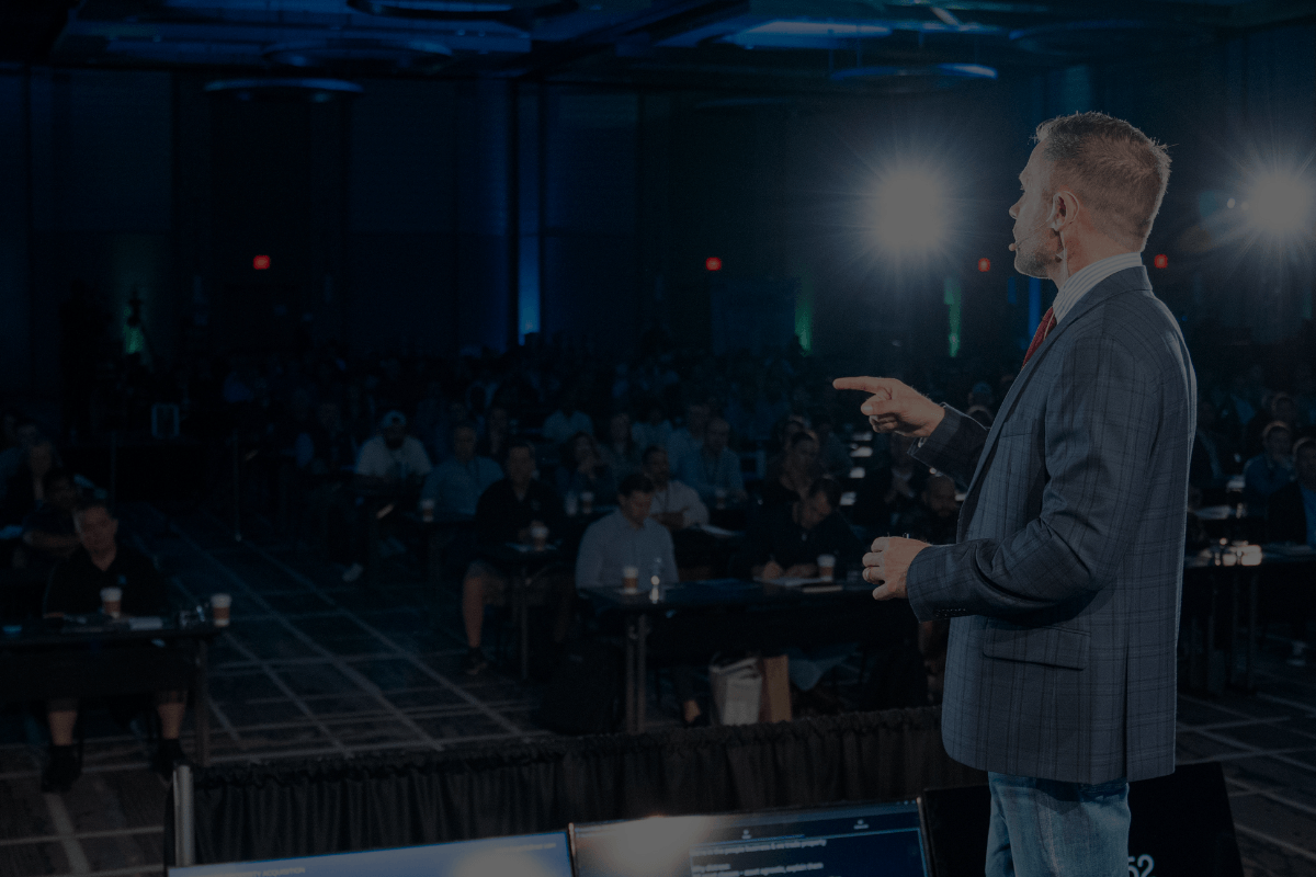 Logan Fullmer speaking on stage at a real estate investing event