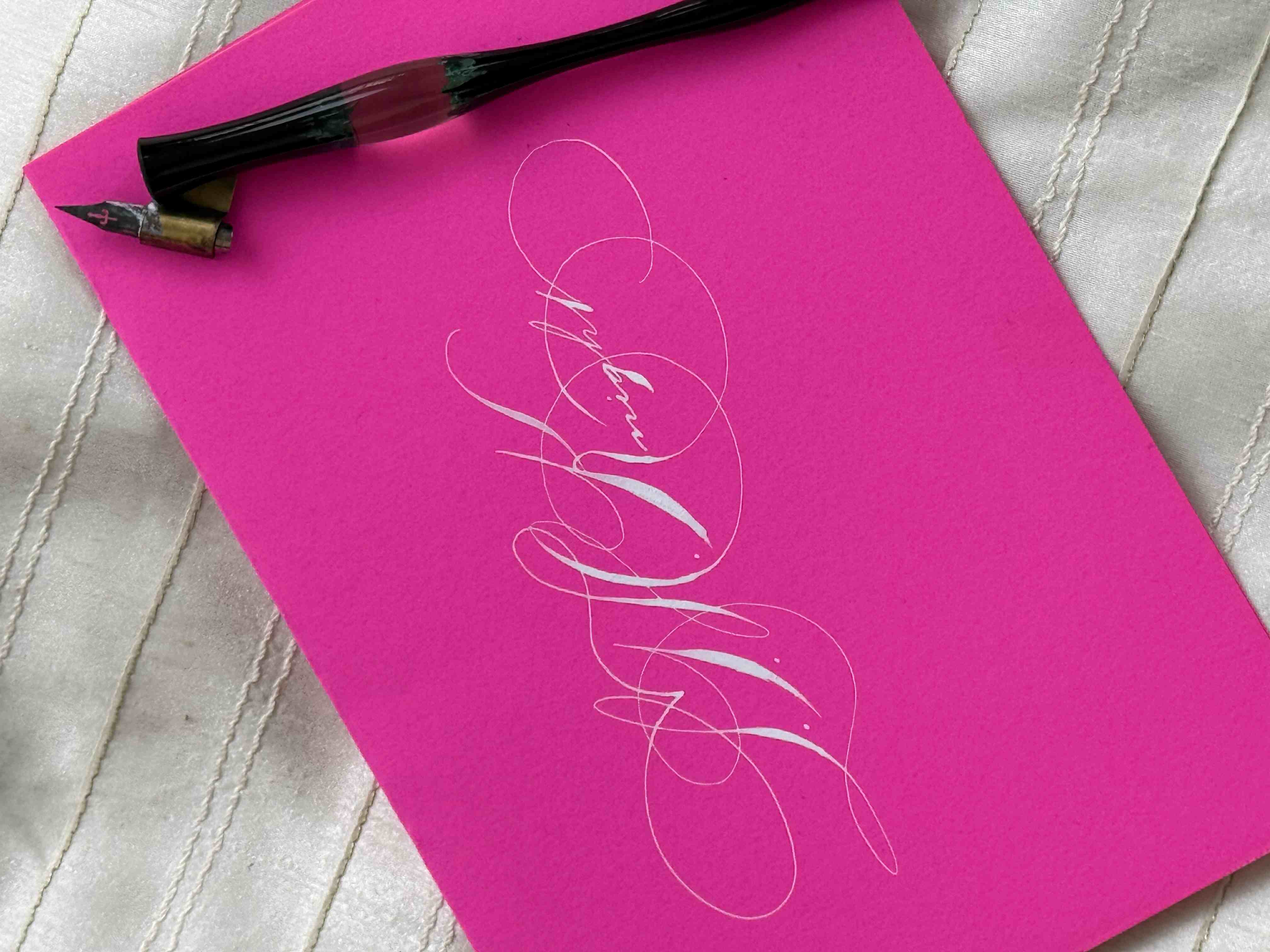 Spencerian signature in white ink on pink cardstock by Lavina Jhangiani
