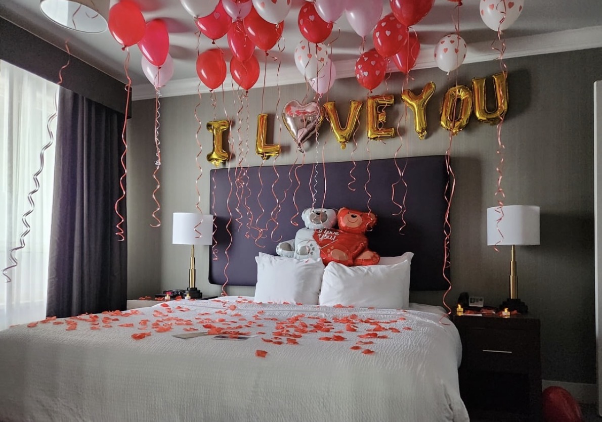 Sculptural balloon arrangement with glowing marquee letters at twilight