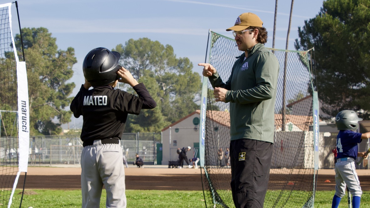 Coach Alec Garcia working with a young hitter