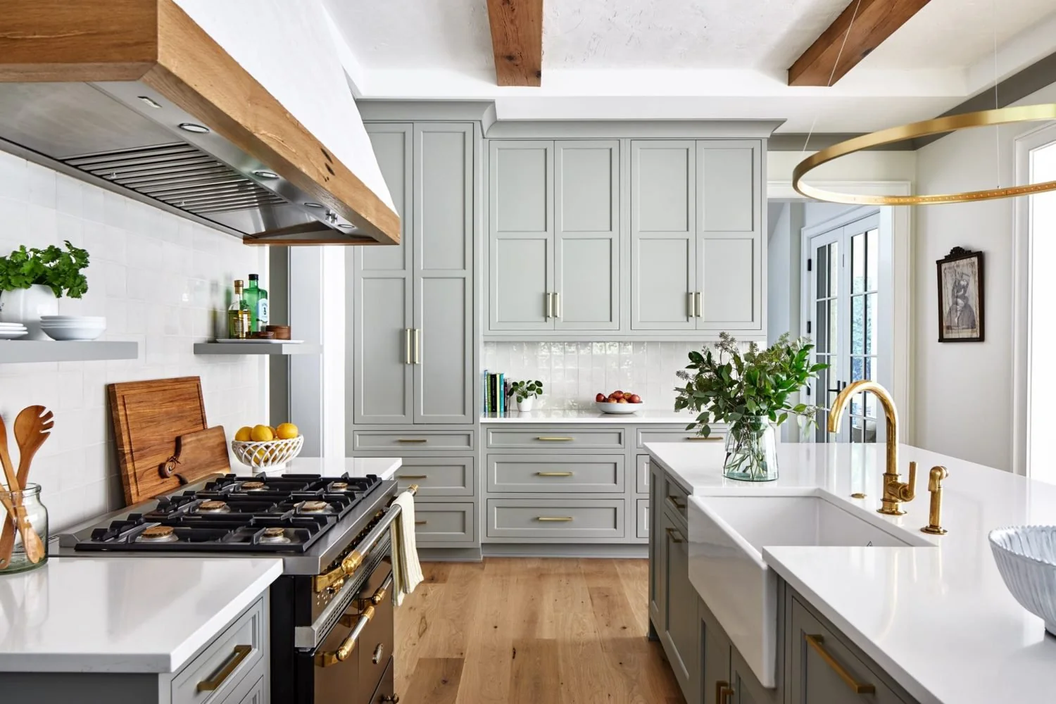 Sage green kitchen cabinetry with a natural wood island