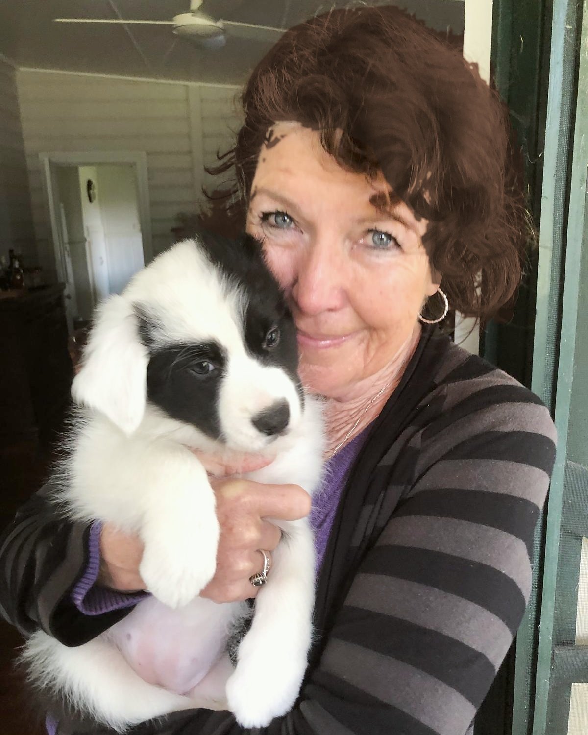 Kim, admin at Barc for Pets, cuddling a black and white puppy