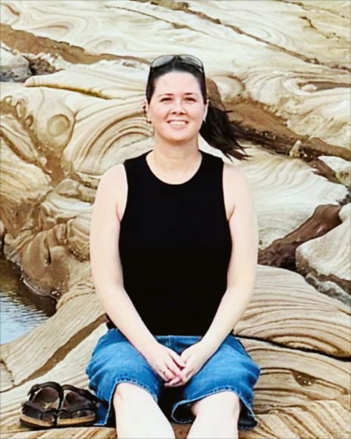 Tammy from sales and client services at Barc for Pets, sitting on sandstone rocks
