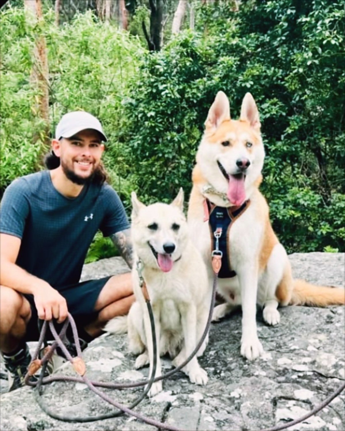 Johnathan, canine care head guide at Barc for Pets, with two husky dogs on a bush trail