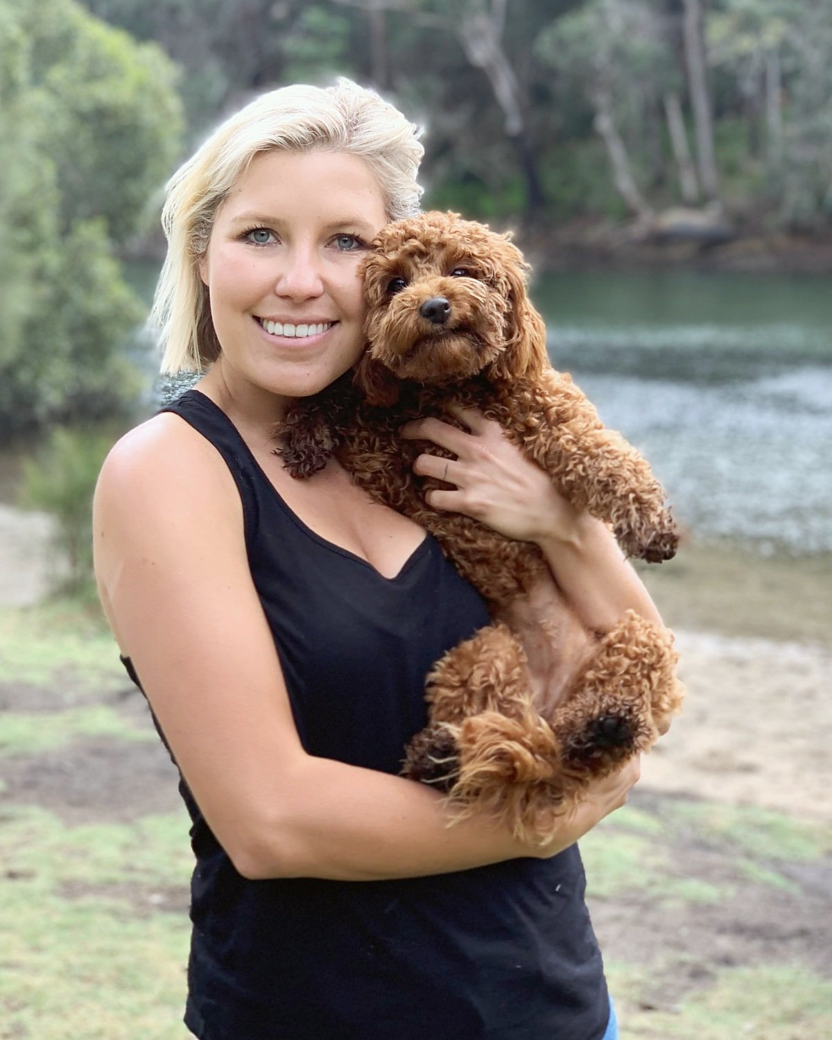 Rebecca, co-founder of Barc for Pets, holding a curly red-brown dog