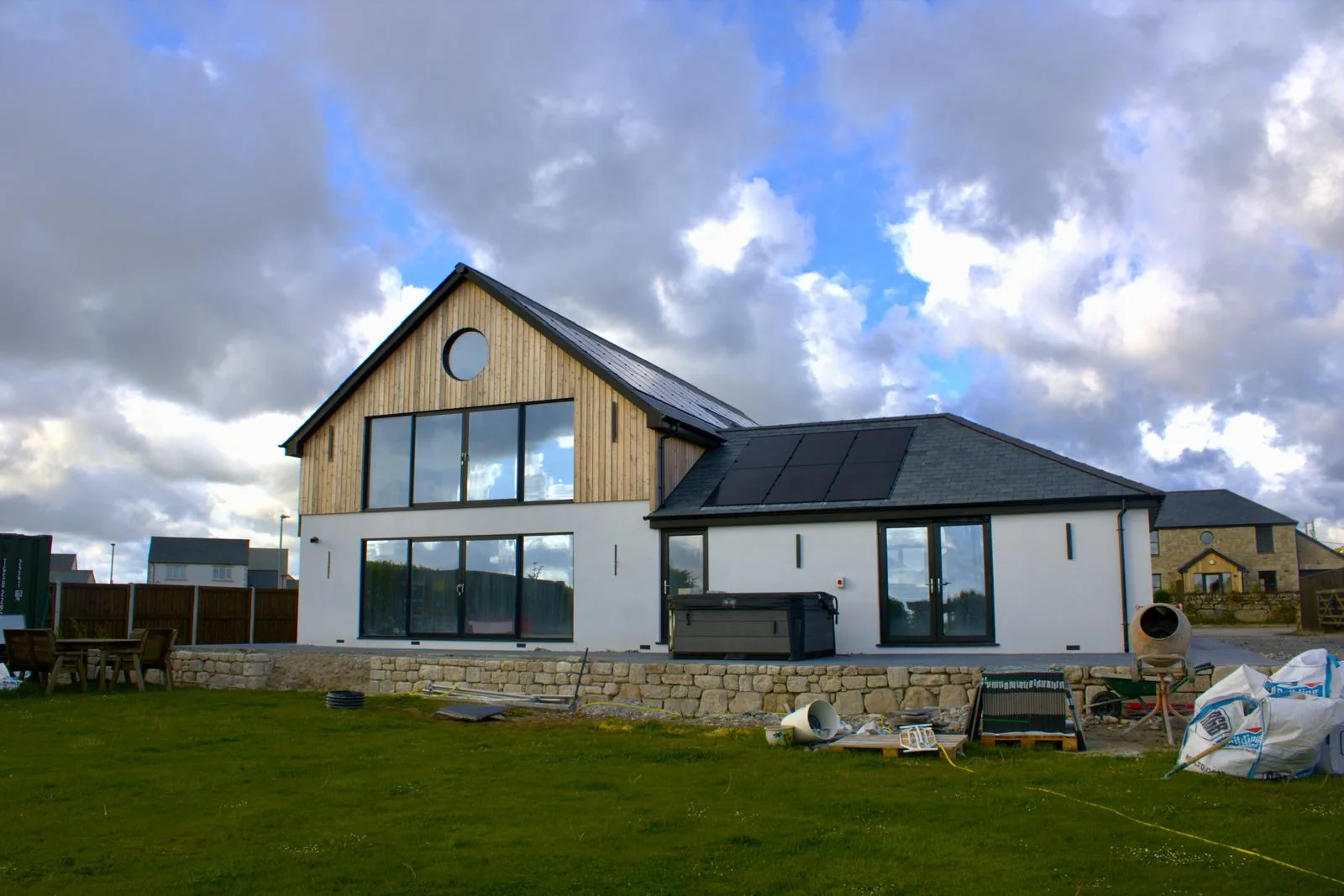 L W Construction running a Cornwall new build from start to finish — exterior during construction, scaffolding and driveway groundworks in progress
