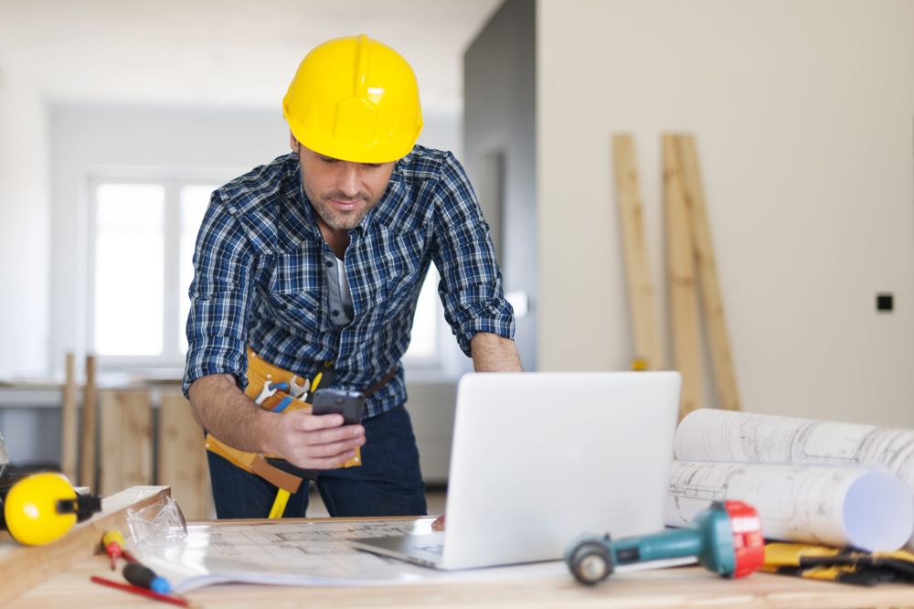 Contractor reviewing a website on a laptop at a job site