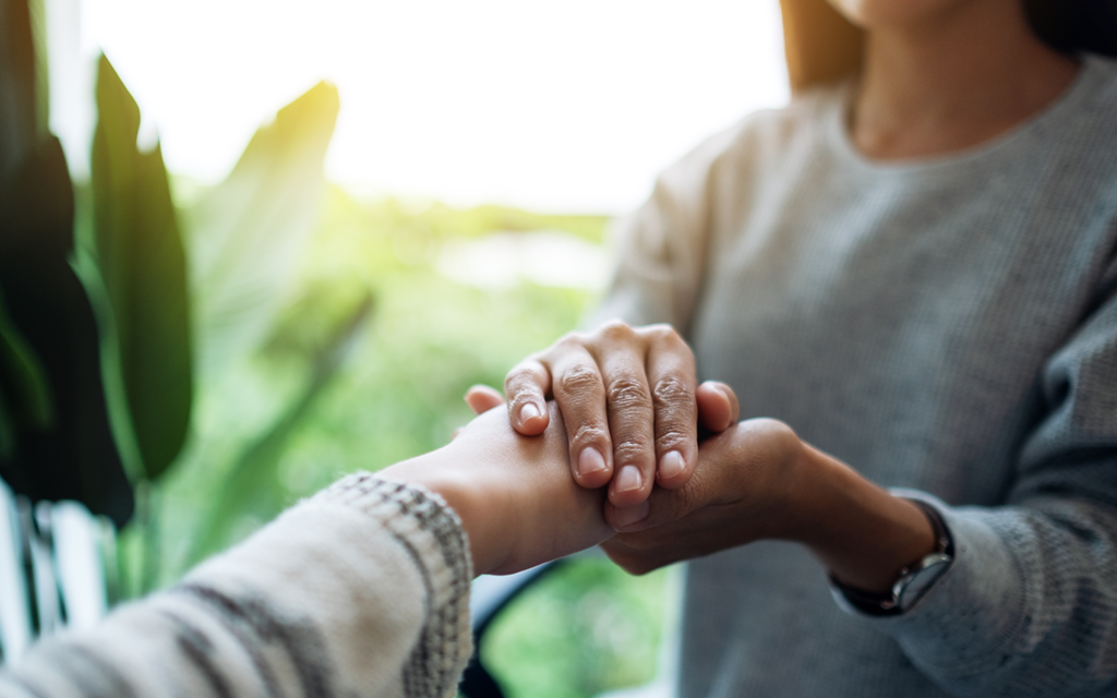 Woman holding another person's hand
