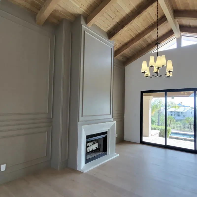 Residential living room with vaulted wood ceiling, paneled walls and fireplace