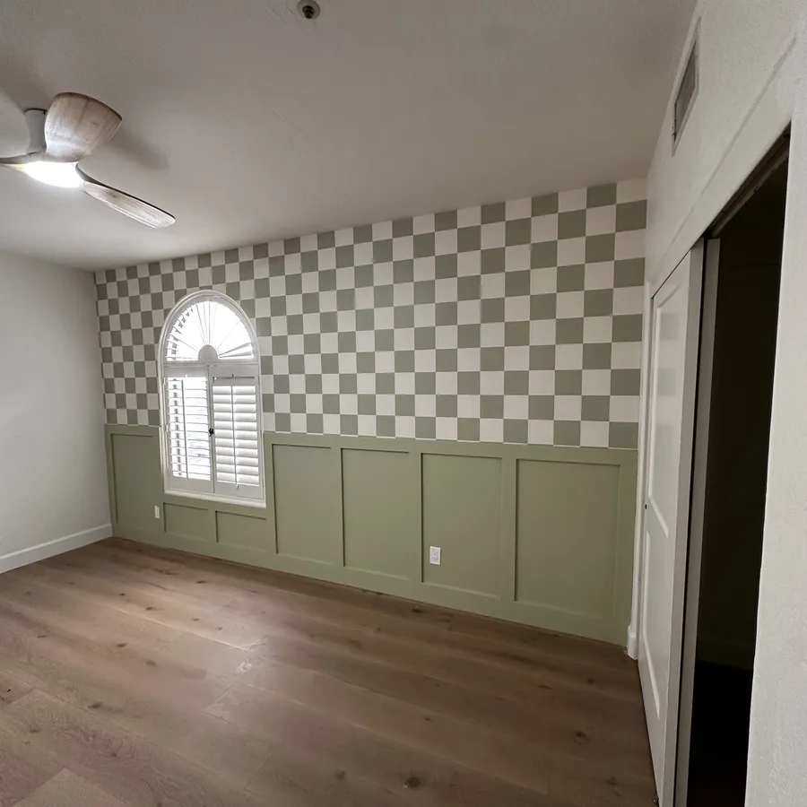 Checkerboard wallpaper installed above green wainscot paneling by R&R Coatings