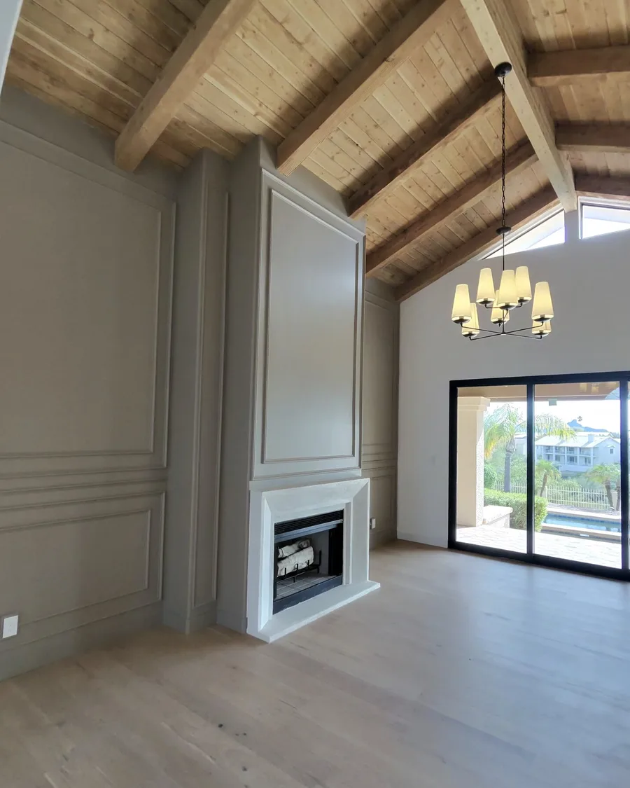 Finished living room with stained wood ceiling and painted paneled walls