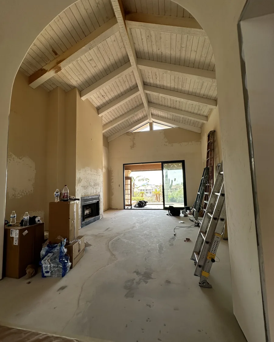 Living room before paint with patched walls and bare ceiling