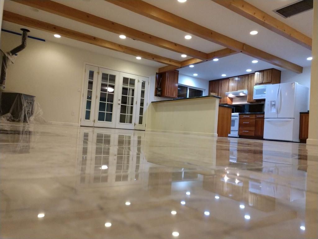 Polished stone floor reflecting kitchen lights