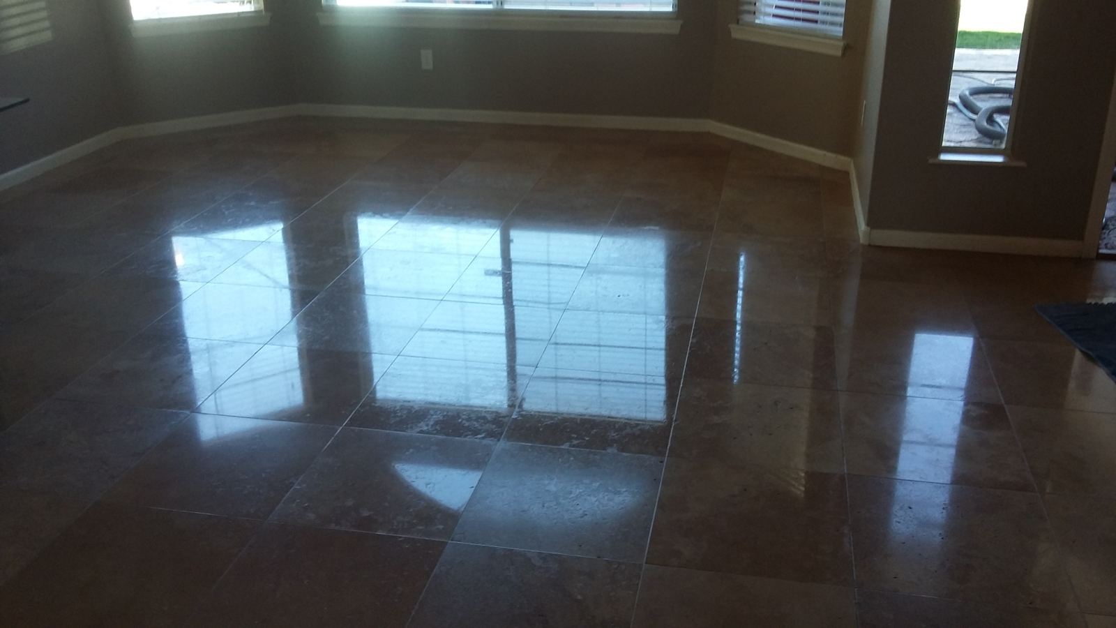 Clean, glossy travertine floor reflecting a window