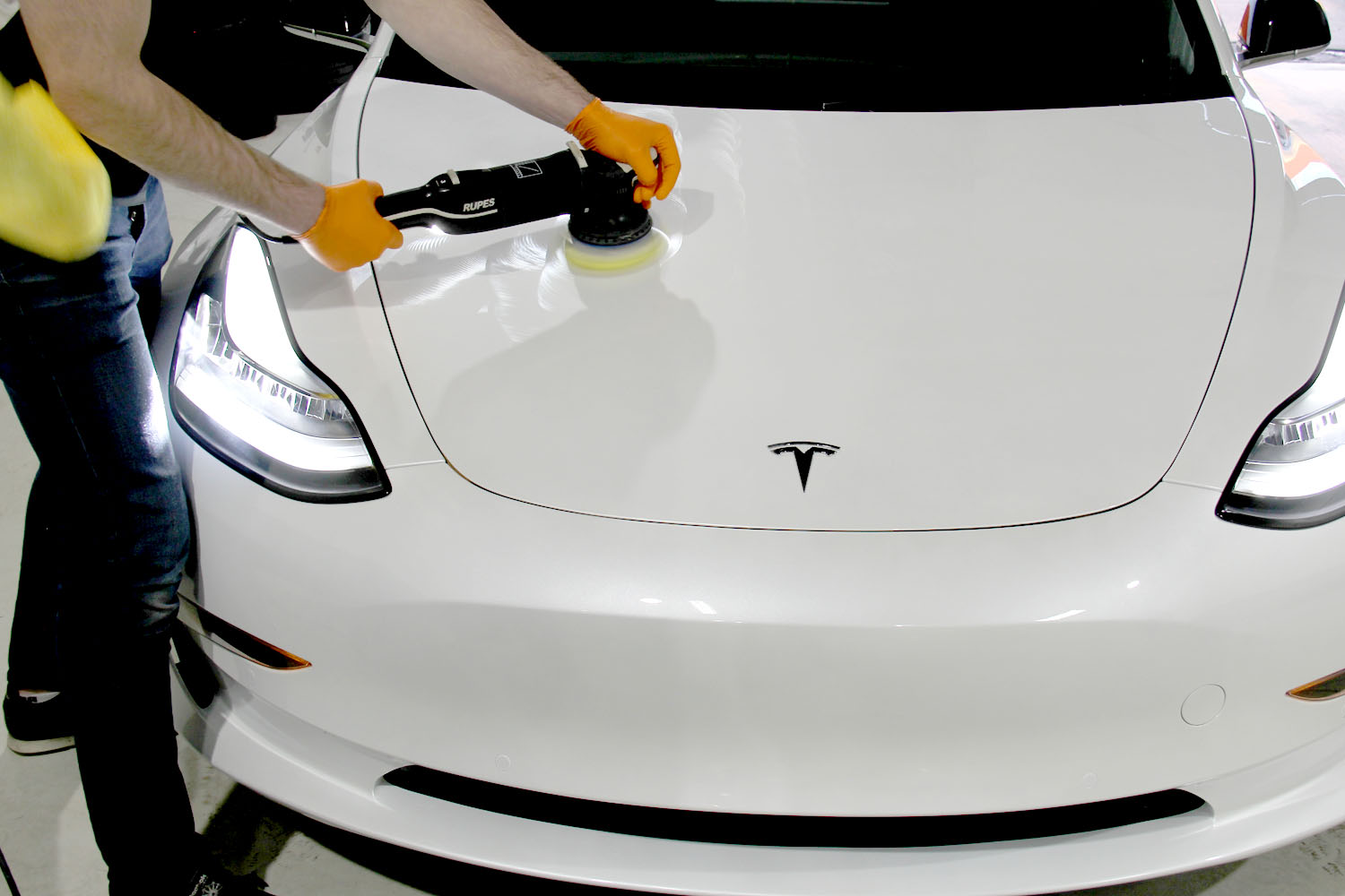 Ceramic coating being machine applied to the hood of a white Tesla Model 3 at Mission Tint