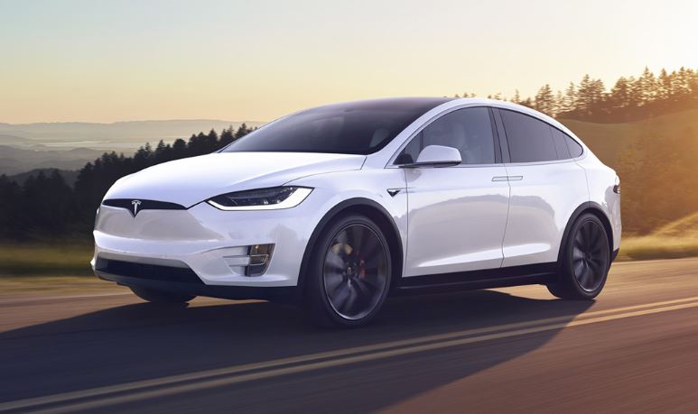 White Tesla Model X on the road at sunset after window tint by Mission Tint