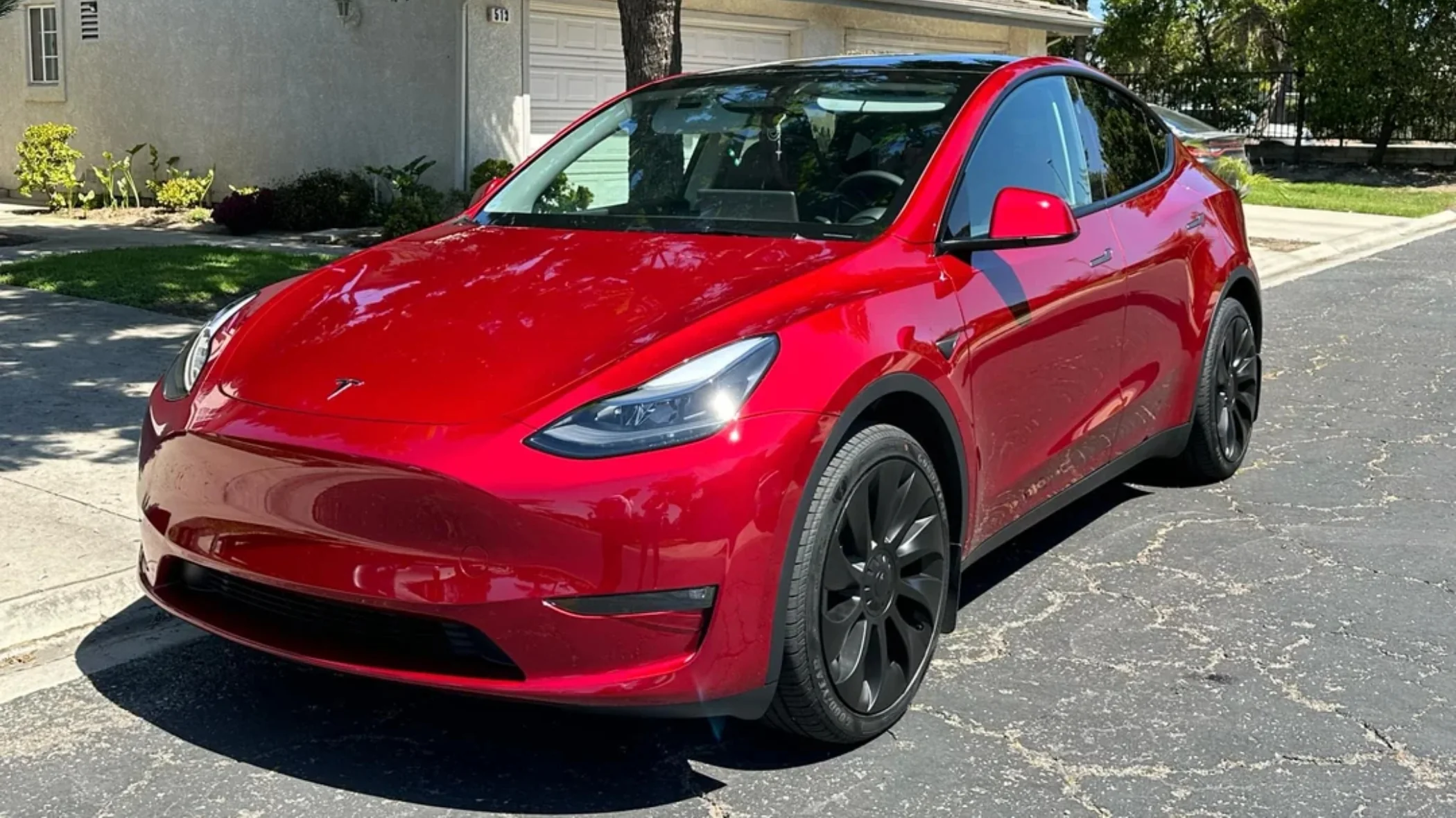 Red Tesla Model Y with a ceramic coated finish on a Florida driveway