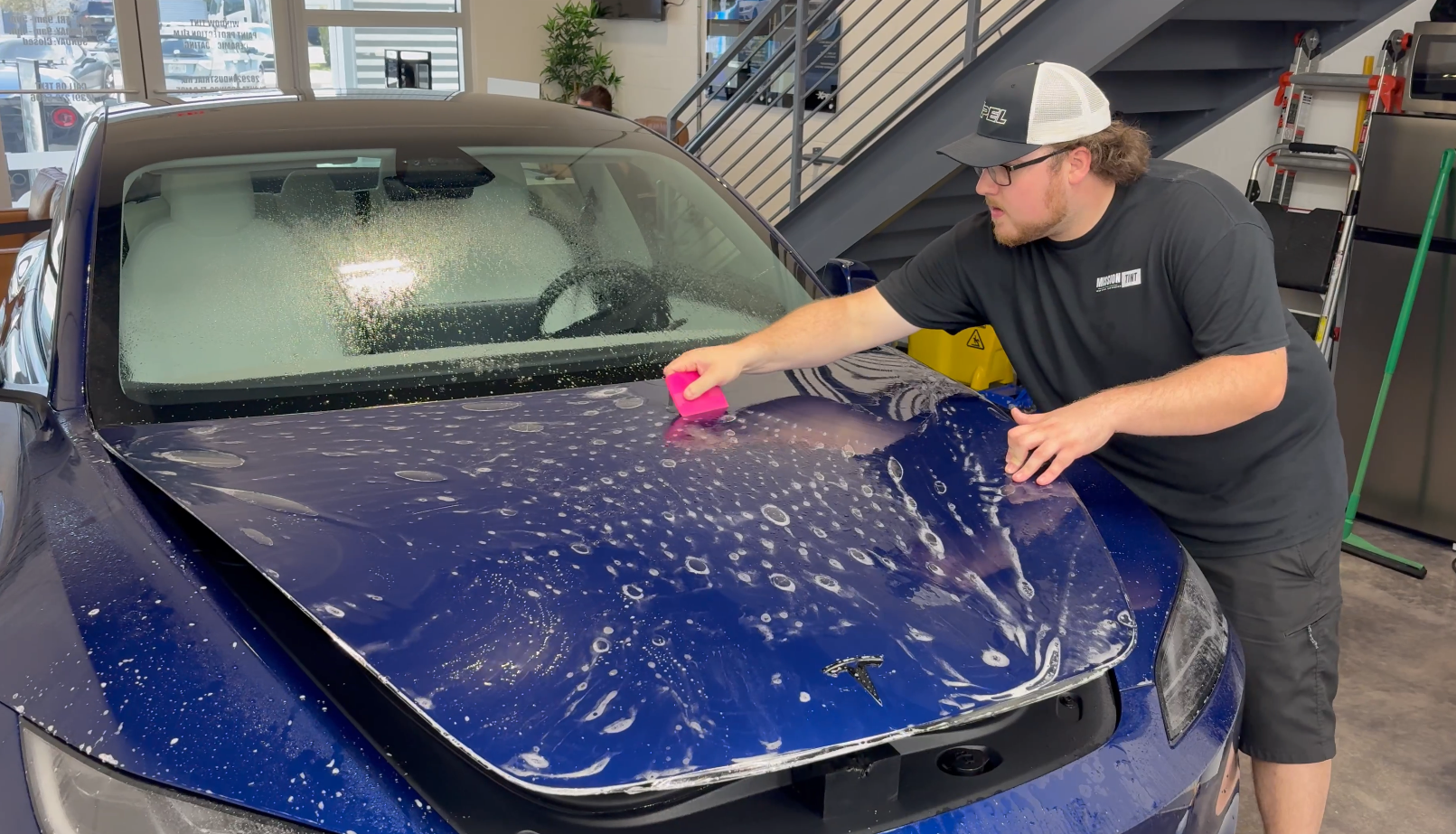 Paint protection film being installed on a Tesla hood at Mission Tint