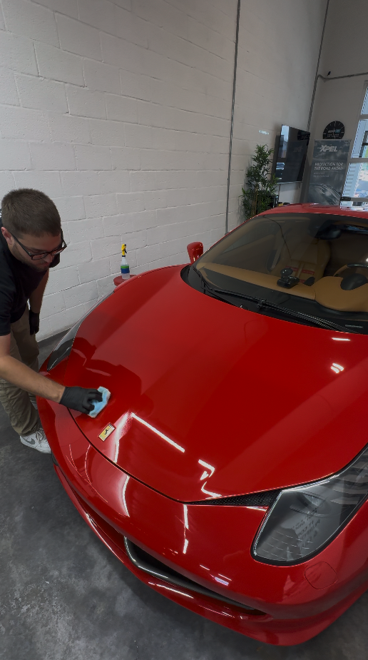 Ceramic coating being applied to a red vehicle hood