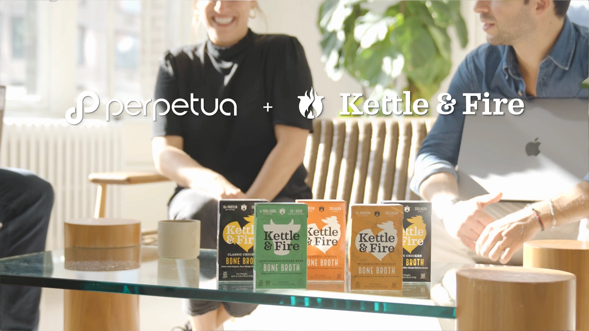Kettle & Fire products on a glass table with Perpetua and Kettle & Fire branding in a sunlit office.