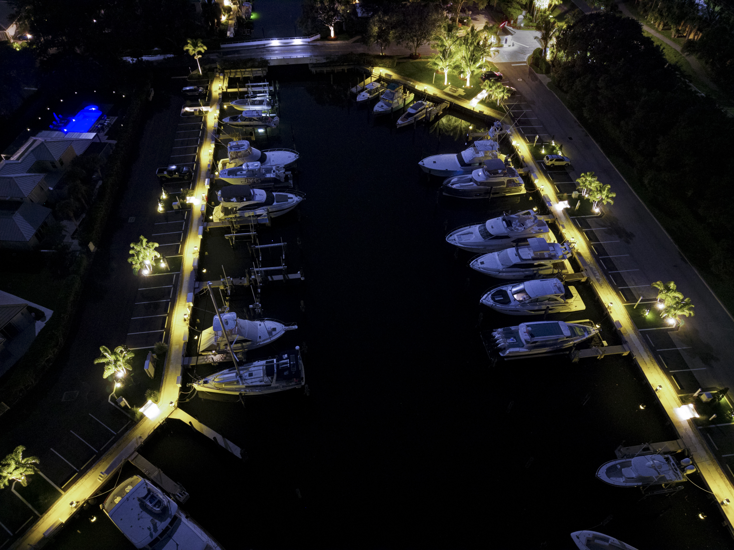 Aerial view of the marina at night, with rows of dock lights outlining every slip
